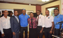 Sports Minister Olivia Grange (centre) is flanked by West Indies players Marlon Samuels (left) and Jerome Taylor (right) on their return home on Tuesday. (Photo courtesy JIS)