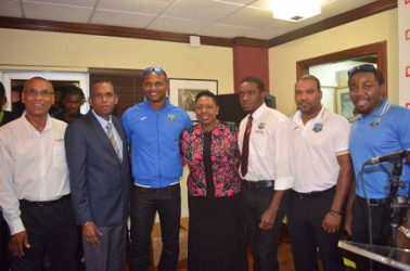Sports Minister Olivia Grange (centre) is flanked by West Indies players Marlon Samuels (left) and Jerome Taylor (right) on their return home on Tuesday. (Photo courtesy JIS)  