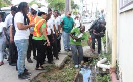 Constituency 10 representative Malcom Ferreira (left) and Mayor Patricia Chase-Green (second, left) along with other councillors inspecting an overflowing septic tank pipe at the Selman Fraser Nursery School in Albouystown