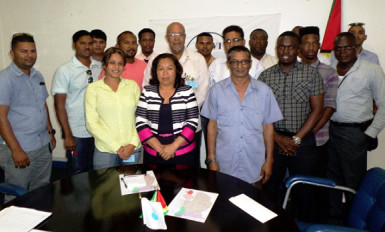 Minister within the Ministry of Communities, Dawn Hastings-Williams (at centre in front row) and Dr Richard Van West-Charles (standing behind the minister) with the contractors. (GWI photo)