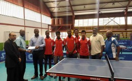 Former national table tennis player Garfield Wiltshire, treasurer of the Guyana Olympic Association (GOA) hands over the sponsorship cheque to president of the Guyana Table Tennis Association (GTTA) Godfrey Munroe. At left is GOA president KA Juman Yassin while GOA General Secretary Hector Edwards is second from right and GTTA secretary/national coach Linden Johnson right.
