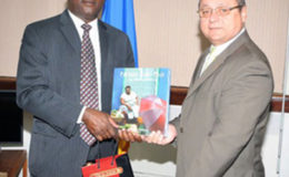 Barbados Minister of Industry Donville Innis exchanging gifts with Cuban envoy Francisco Fernandez Pena in Bridgetown recently.
