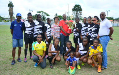 GFF President Wayne Forde in the presence of Minister within the Ministry of Indigenous Peoples Valerie Garrido-Lowe hands over the championship trophy to the victorious Fruta Conquerors-A side following the conclusion of the NAWF women’s Championships yesterday. (Orlando Charles photo)