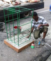 A worker installs a garbage receptacle on Regent Street. (Photo by Keno George) 