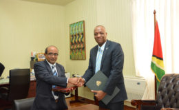 Indian High Commissioner to Guyana, Venkatachalam Mahalingam (left) and Minister of State, Joseph Harmon shake hands after the signing (Ministry of the Presidency photo)
