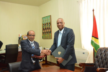 Indian High Commissioner to Guyana, Venkatachalam Mahalingam (left) and Minister of State, Joseph Harmon shake hands after the signing (Ministry of the Presidency photo) 