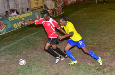 Gregory Richardson (yellow) of Pele battling to win the ball from a Buxton United player during their team’s matchup in the GFF Stag Beer Elite League at the GFC ground. (Orlando Charles photo)