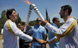 Olympic flame second torch bearer, former volleyball player Giovane Gavio from Brazil (L), passes the torch to third bearer Dimitrios Mougios as they attend the Olympic flame lighting ceremony for the Rio 2016 Olympic Games on the site of ancient Olympia, Greece, April 21, 2016. REUTERS/Yannis Behrakis
