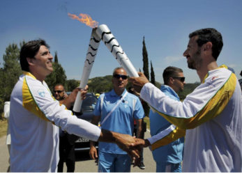 Olympic flame second torch bearer, former volleyball player Giovane Gavio from Brazil (L), passes the torch to third bearer Dimitrios Mougios as they attend the Olympic flame lighting ceremony for the Rio 2016 Olympic Games on the site of ancient Olympia, Greece, April 21, 2016. REUTERS/Yannis Behrakis
