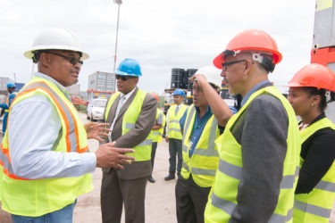  An official of Tiger Tanks (left) speaks about the company’s work in Guyana during a tour of Muneshwers new port facility at Houston yesterday.   