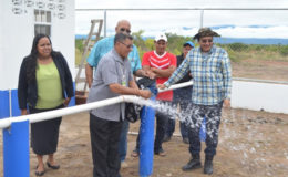 Minister of Indigenous Peoples’ Affairs Sydney Allicock turns on the main at the well at Culvert City, in Region Nine in the presence of the Guyana Water Incorporated’s Chief Executive Officer Richard Van West- Charles and other officials on Wednesday. (Government Information Agency photo)