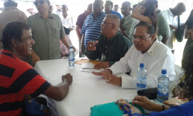 Prime Minister Moses Nagamootoo (seated, right) reacts as he listens to a resident’s concerns yesterday’s ‘Meet the Public Day’ in Corentyne, Berbice