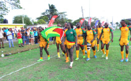 Winners! The national 15s men’s rugby team marches with the Golden Arrowhead following their 48-17 victory over Barbados in the opening game of the 2016 Rugby America’s North 15s championship yesterday at the National Park. (Orlando Charles photo)
