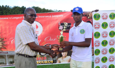 All-rounder Ronaldo AliMohammed collects his MVP trophy from referee Grantley Culbard