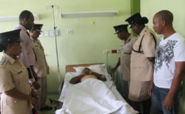 Assistant Commissioner David Ramnarine and other senior officers of the Guyana Police Force visit wounded Lance Corporal Andrew Richardson at Georgetown Public Hospital. (Guyana Police Force photo)