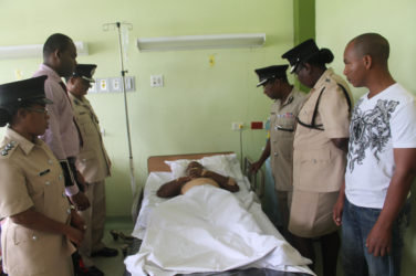 Assistant Commissioner David Ramnarine and other senior officers of the Guyana Police Force visit wounded Lance Corporal Andrew Richardson at Georgetown Public Hospital. (Guyana Police Force photo)