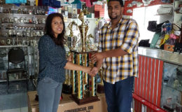 Devi Sunich presenting the champion’s trophy of the feature D and Lower event of the Labour Day Classic to Nasrudeen Mohamed (Jumbo Jet Jr.) on Thursday at the Trophy Stall.