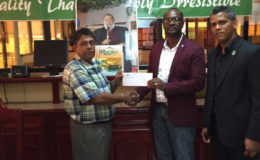 GFF Boss Wayne Forde (centre) collects the cheque for the tickets from Bakewell General Manager Rajin Ganga while GFF Marketing and Sponsorship Director Dario McKelmon looks on.
