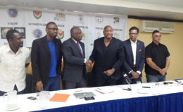 CBC President Glyne Clarke (3rd from left) and GABF President Nigel Hinds shaking hands following the signing of the agreement signaling Guyana as the host for the CBC u16 Male and Female Championships while CBC Vice President Patrick Haynes (2nd from right), NSC chief Christopher Jones (2nd from left) and YBG Director Chris Bowman (left) look on