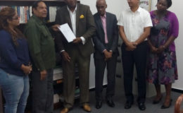 Prime Minister Moses Nagamootoo receives the final report from Convenor Nigel Hughes in the presence of from left: Geeta Chandan-Edmond, Professor Duke Pollard, Gino Persaud and Tamara Khan. Chandan-Edmond and Persaud are members of the Steering Committee while the others would have provided support. 