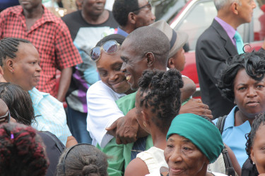 Winston Harding receives a hug from one of his supporters in City Hall’s compound yesterday. (Photo by Keno George)