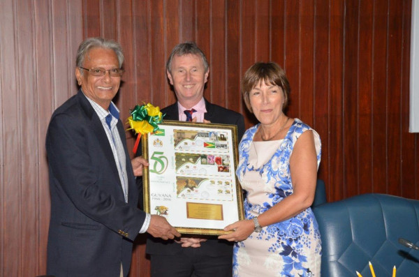 Baroness Dawn Primarolo receives a token of appreciation from Minister of Education, Dr. Rupert Roopnaraine at the end of the session today at the Ministry of the Presidency. Nigel Evans, another member of the delegation is at the centre. (Ministry of the Presidency photo)
