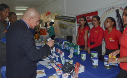 Minister of Public Health Dr. George Norton viewing one of the exhibits at the fair (GINA photo)