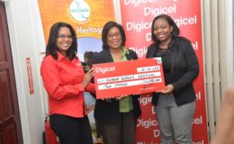 Digicel handing over a cheque for $2m to Minister of Tourism, Cathy Hughhes 