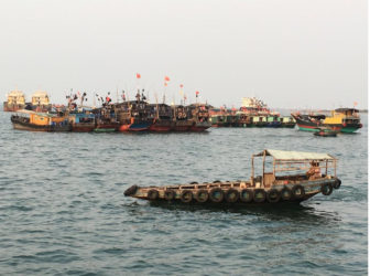 Fishing boats with Chinese national flags are seen at a harbour in Baimajing, Hainan province, April 7, 2016. REUTERS/Megha Rajagopalan 