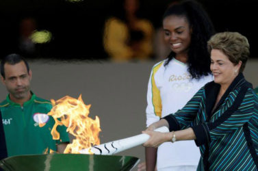 Brazil’s President Dilma Rousseff (R) lights a cauldron with the Olympic Flame next to Fabiana Claudino, captain of the Brazilian volleyball team, during the Olympic Flame torch relay at Planalto Palace in Brasilia, Brazil, yesterday. REUTERS/UESLEI MARCELINO