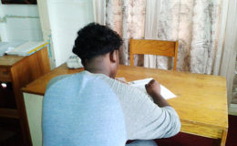 Davenand Dhandhari writing the CAPE exam