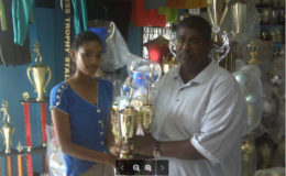 In picture Areefa Yusuf representative of Trophy Stall, presents the trophies to Jiaram Ramdeen, president of the Guyana Draughts Association.
