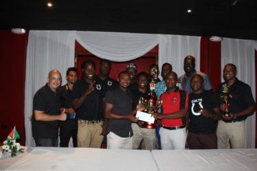 Captain of the Colts Basketball team Dave Causway (centre) is all smiles as he receives the tourney winnings from Mackeson Brand Manager Jamaal Douglas while other members of the team look on and display their respective accolades 
