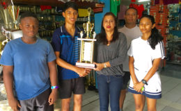 Ms. Devi Sunich of Trophy Stall, Junior Sportsman of the year Narayan Ramdhani, GBA Rep Marlon Chung and some Junior Players display some of the trophies that are up for grabs.