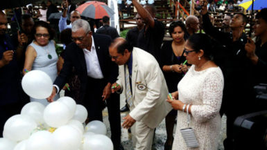 President David Granger and Prime Minister Moses Nagamootoo along with their spouses writing their personal commitments to the promotion of social cohesion on white helium filled balloons, which were later released. (OPM Photo) 