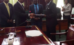 Attorney General and Minister of Legal Affairs Basil Williams (left) hands over a copy of the CoI report to Speaker of the National Assembly Dr. Barton Scotland.  (GINA photo)
