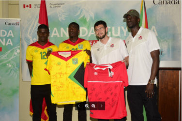 Golden Jaguars Captain Colin nelson (2nd from left) and Canada’s Captain Maxime Crépeau (2nd from right) displaying the signed team jerseys featuring the complete team rosters ahead of their historic showdown while other members of the respective teams inclusive of Guyanese Dwight Peters (left) look on.