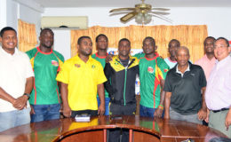 Captains Richard Staglon and Hubert Thomas (centre) embrace in the presence of President of the GRFU, Peter Green (right), Jamaica Manager Tezra Sannister (3rd left) and members of Guyana’s squad yesterday at Olympic House. (Orlando Charles photo)
