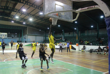 Andrew Johnson of Plaisance Secondary in the process of scoring a layup during his team’s matchup with Tutorial High at the Cliff Anderson Sports Hall