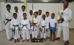 Sensei Winston Dunbar and Sadella Britton holding trophies, with some of the participants.