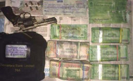 The money, a firearm, a cheque and several rounds that were found by the police buried in a bucket behind the ‘A’ Field, Sophia squatting area house