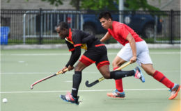 Guyana’s Aroydy Branford in the act to receive the ball while being pursued by his Mexico marker during their matchup in the Pan American Junior Hockey Championships at the University of Toronto Facility
