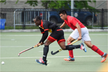 Guyana’s Aroydy Branford in the act to receive the ball while being pursued by his Mexico marker during their matchup in the Pan American Junior Hockey Championships at the University of Toronto Facility 