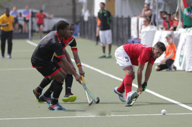 Guyana’s Kareem McKenzie (left) and Mark Sergeant in the process of challenging a Mexican player for the ball during their 5-8 Positional Tourney match at the University of Toronto Facility in the Pan American Junior Hockey Championships 
