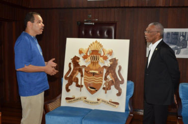 Jonathan Locke (left) explains to President David Granger the effort which was expended to create the work (Ministry of the Presidency photo) 