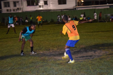  Job Caesar of Cross Street (left) trying to maintain possession of the ball while being challenged by an Old School Ballers defender during their matchup at the Santos Training Area in the Ministry of Health/Petra Soft Shoe Championship. 