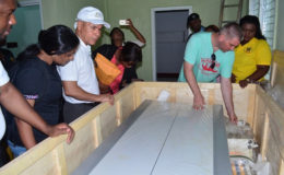 Public Health Minister, Dr George Norton (third from left) and officials examining the x-ray machine at Leguan Cottage Hospital. The machine has been in the crate it arrived in for over five years (GINA photo)