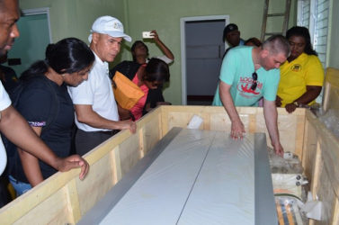 Public Health Minister, Dr George Norton (third from left) and officials examining the x-ray machine at Leguan Cottage Hospital. The machine has been in the crate it arrived in for over five years (GINA photo)