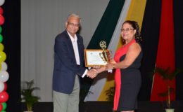 Minister of Education, Dr. Rupert Roopnaraine presents an award to Rita Fox, outstanding educator from Region Ten (GINA photo)
