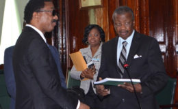 Attorney General and Minister of Legal Affairs Basil Williams (left) hands over a copy of the COI report to Speaker of the National Assembly Dr. Barton Scotland.  (GINA photo)